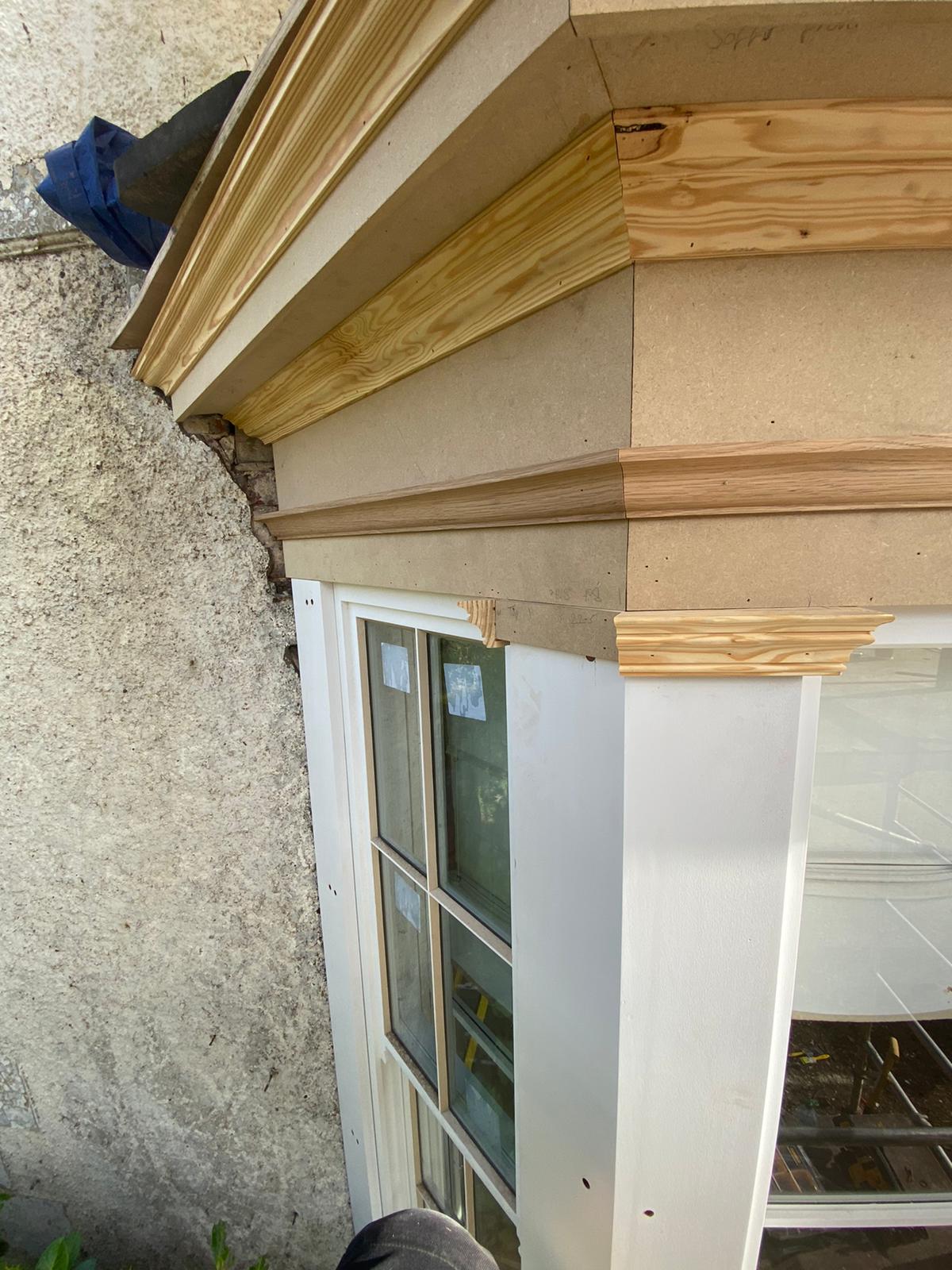 Timber cornice detail above a painted window frame