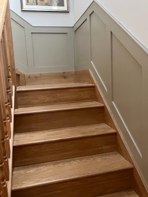 Oak-clad stairs and panelled wall