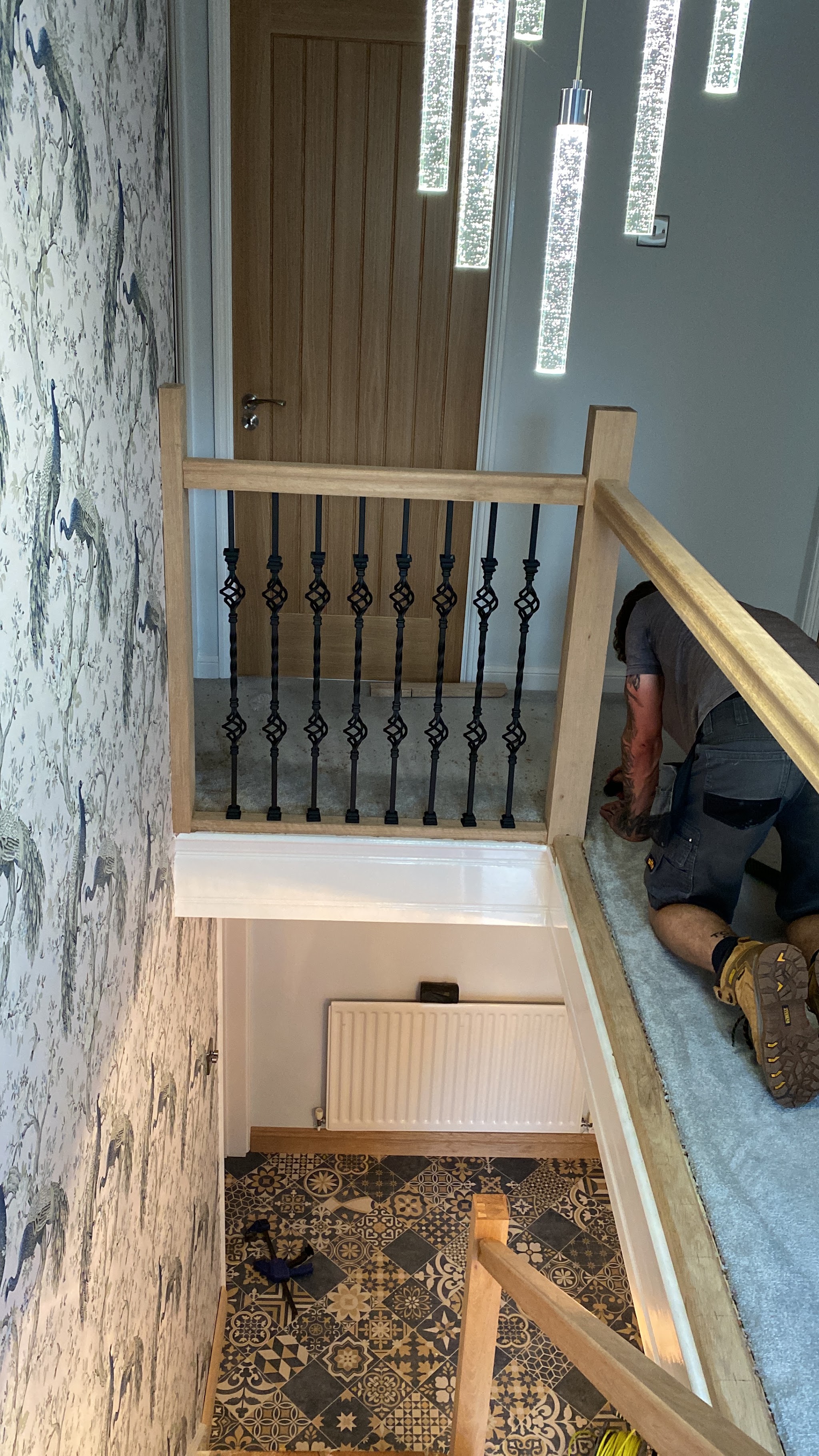 Oak balustrade with black iron spindles around a stairwell