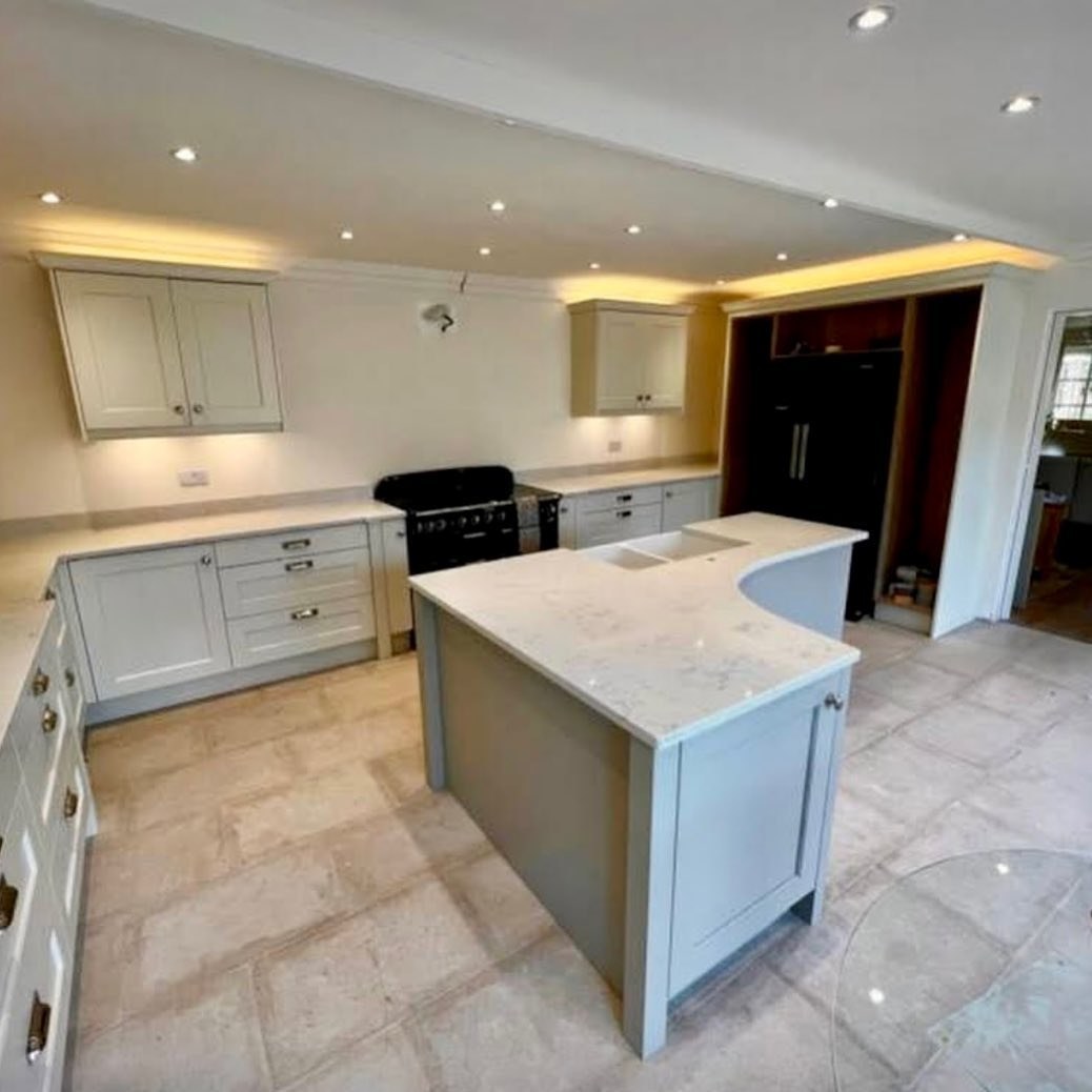 Finished kitchen with a curved island, light worktops and a range cooker