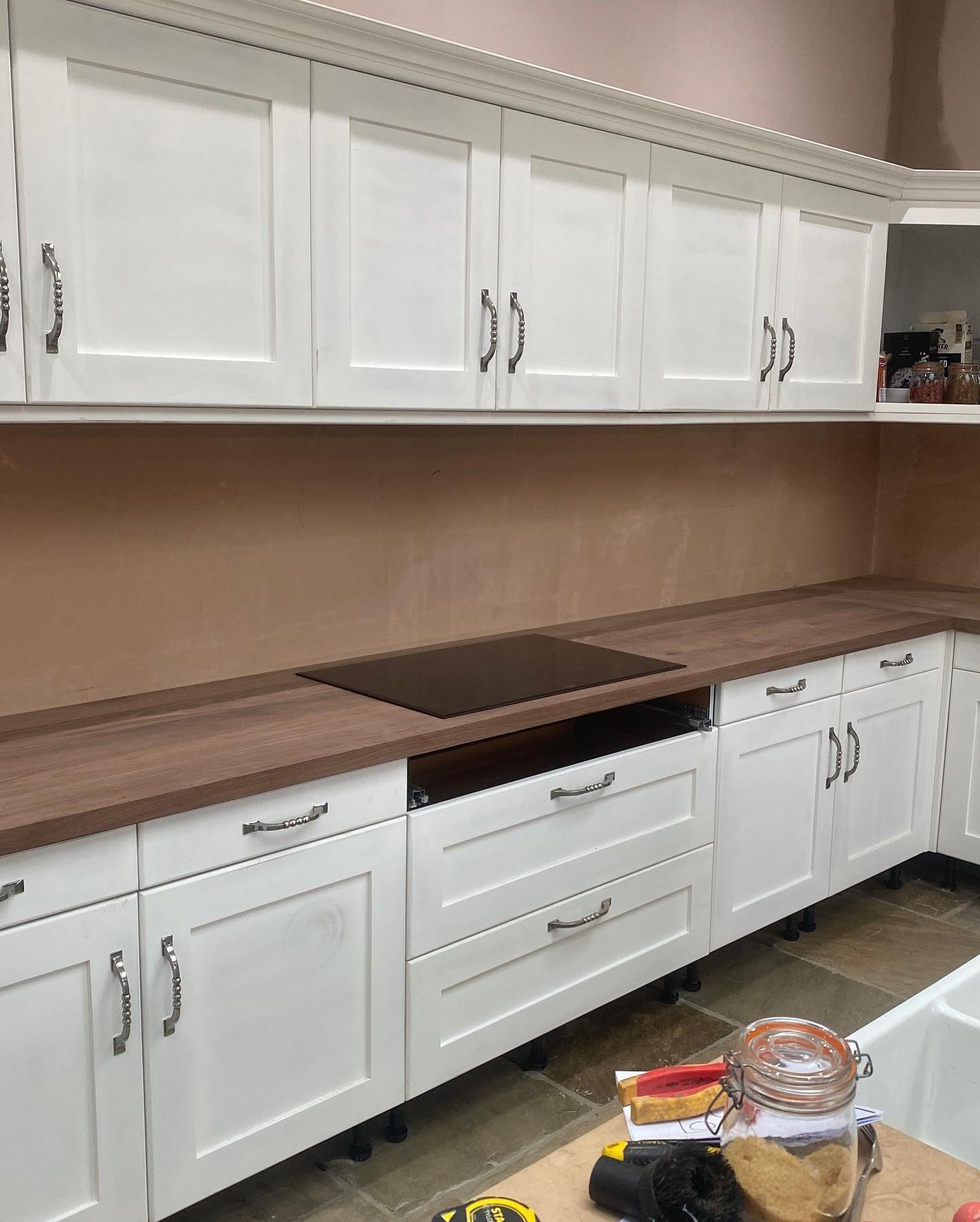 White shaker wall and base units with a wood worktop