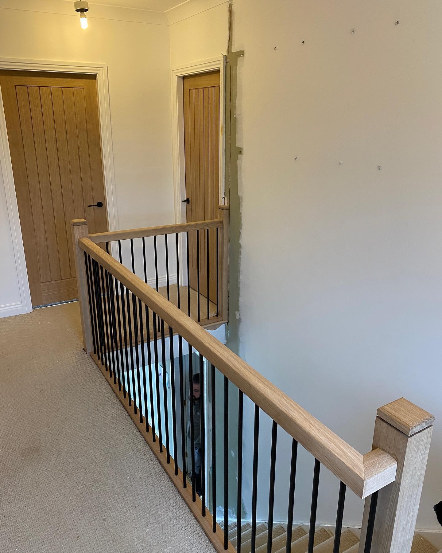 Oak handrail and black spindles around a landing