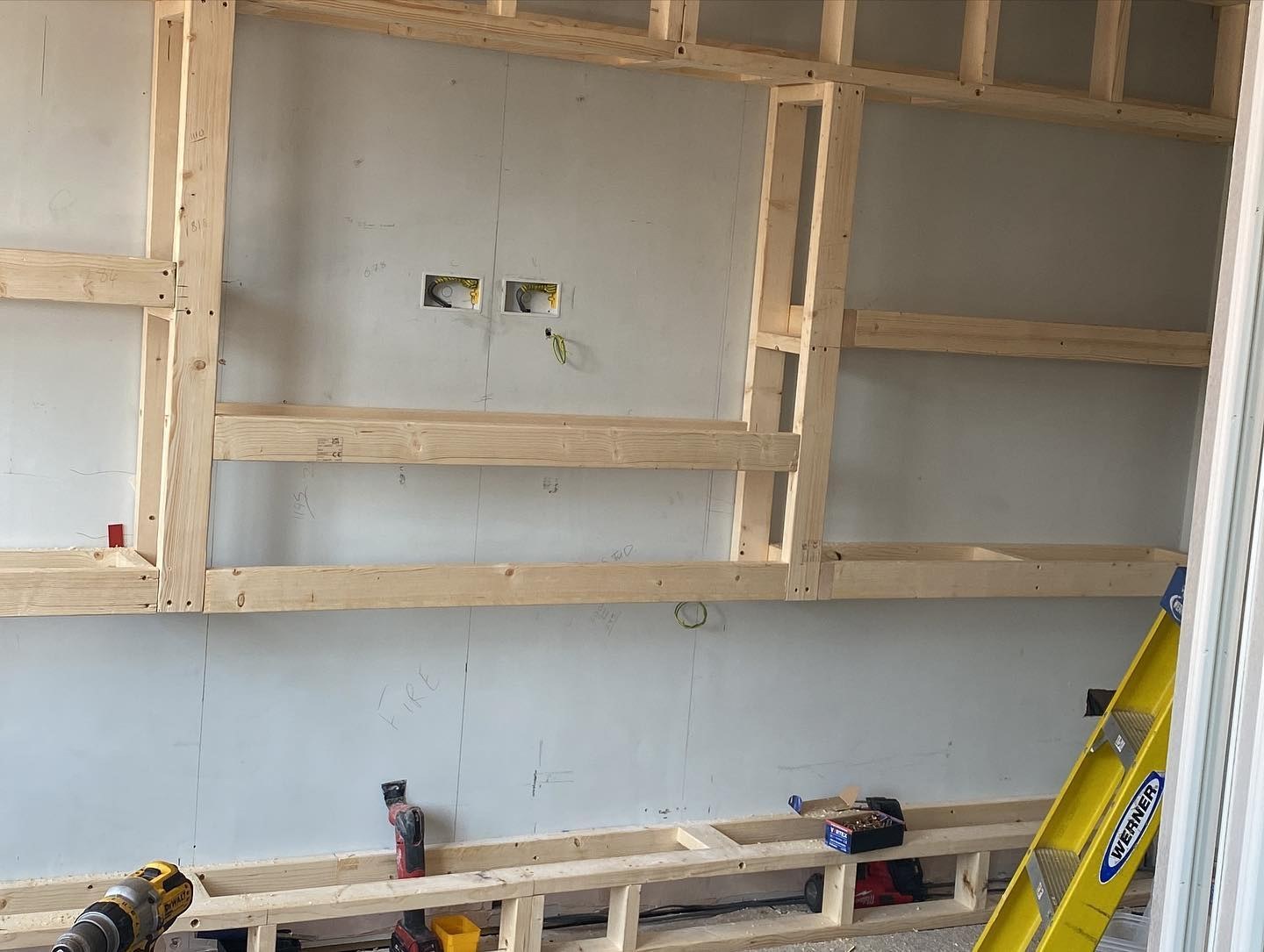 Timber framing for a media wall, with alcoves and a fire opening marked out
