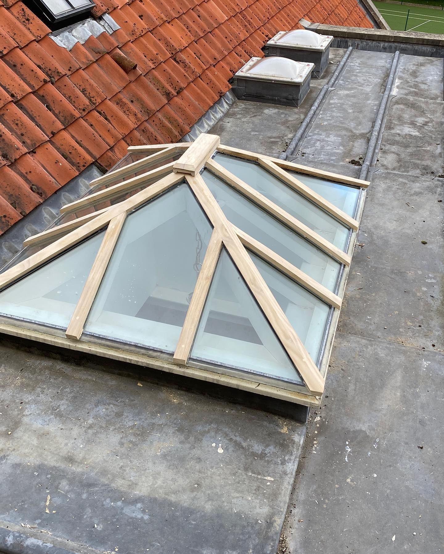 Finished roof lantern on a flat roof beside clay tiles